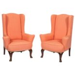 A pair of wingback armchairs in George II style, 20th century; with wing back and outscrolled arms,