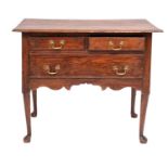 A George II pine lowboy side table, mid 18th century; the top with moulded edges,