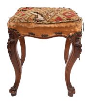 A Victorian carved square walnut stool; with an upholstered stuffover seat in needlework,