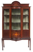 An Edwardian mahogany and inlaid display cabinet; of bowed breakfront outline,