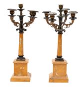 A pair of Charles X patinated and parcel gilt bronze and marble mounted five light candelabra,