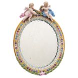 A Meissen porcelain wall mirror of oval form applied with ribbon tied laurel and surmounted with