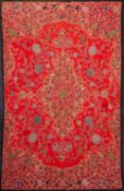 A Persian silk embroidered table cover worked with an arabesque design of stylised flowers and