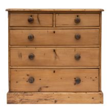 A Victorian pine chest of drawers, late 19th century; the top with rounded front corners,