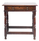 A 17th-century oak rectangular side table; an overhanging moulded top above a frieze drawer,
