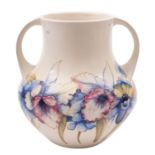 A Walter Moorcroft pottery vase, of two handled form and tube lined in the Orchid pattern,