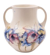 A Walter Moorcroft pottery vase, of two handled form and tube lined in the Orchid pattern,