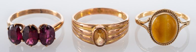 Three gemset rings, including a 9ct gold tiger's eye ring; a 9ct gold citrine ring; and a garnet,