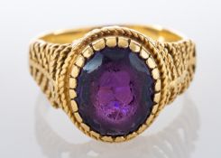 An oval, mixed-cut purple paste ring, stamped '750' ring size L, total weight ca. 5gms.