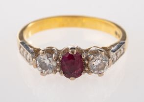 An 18ct ruby and diamond ring, the oval cut ruby set between two brilliant cut diamonds,