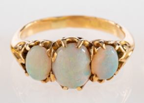 A three stone opal ring, set with three oval cabochon opals in claw settings,