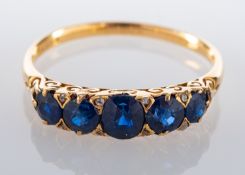 A round, mixed-cut and cushion-cut sapphire, five-stone ring, with rose-cut diamond spacers,
