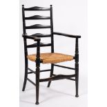 An Edwardian ebonised ash ladderback elbow chair, with ball-shaped finials,