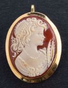 A shell cameo brooch/ pendant, depicting the bust of a lady, stamped '750', total length (inc.
