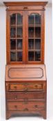 An Edwardian oak bureau bookcase in the Jacobean style; the upper part with a moulded cornice,