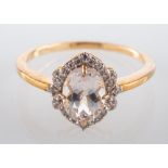 A 9ct gold ring, with an oval, mixed-cut, light brown topaz and CZ surround, ring size N,
