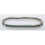 An emerald and diamond tennis bracelet,