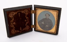 Victorian Photography, a cased hand tinted ambrotype portrait of a seated gentleman,