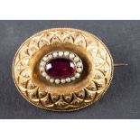 A foil backed, probably red paste and seed pearl locket brooch, with glazed compartment to verso,