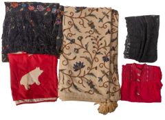 A quantity of various textiles, including a floral embroidered black silk shawl with tassel fringe,