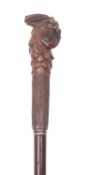 An early 20th century walking cane with carved parrot head handle, with inset glass eyes,