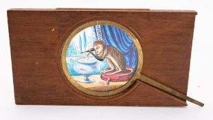 A 19th Century magic lantern lever slide of a monkey with a fork over a fish bowl, unsigned,