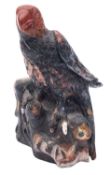 A hardstone model of a bird of prey, seated on a naturalistic carved base, 16cm high.