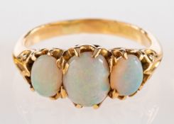 A three stone opal ring, set with three oval cabochon opals in claw settings, ring size O 1/2.