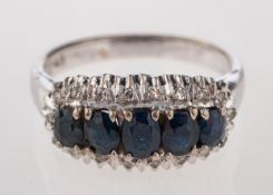 A sapphire and diamond ring, the central row of oval cut sapphires with eight diamonds to the