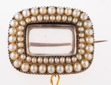 A Victorian seed pearl brooch, cushion shaped with vacant glass locket to centre, within a double