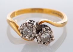 An 18ct gold and diamond two stone ring, set with two brilliant cut diamonds, approximately 0.20