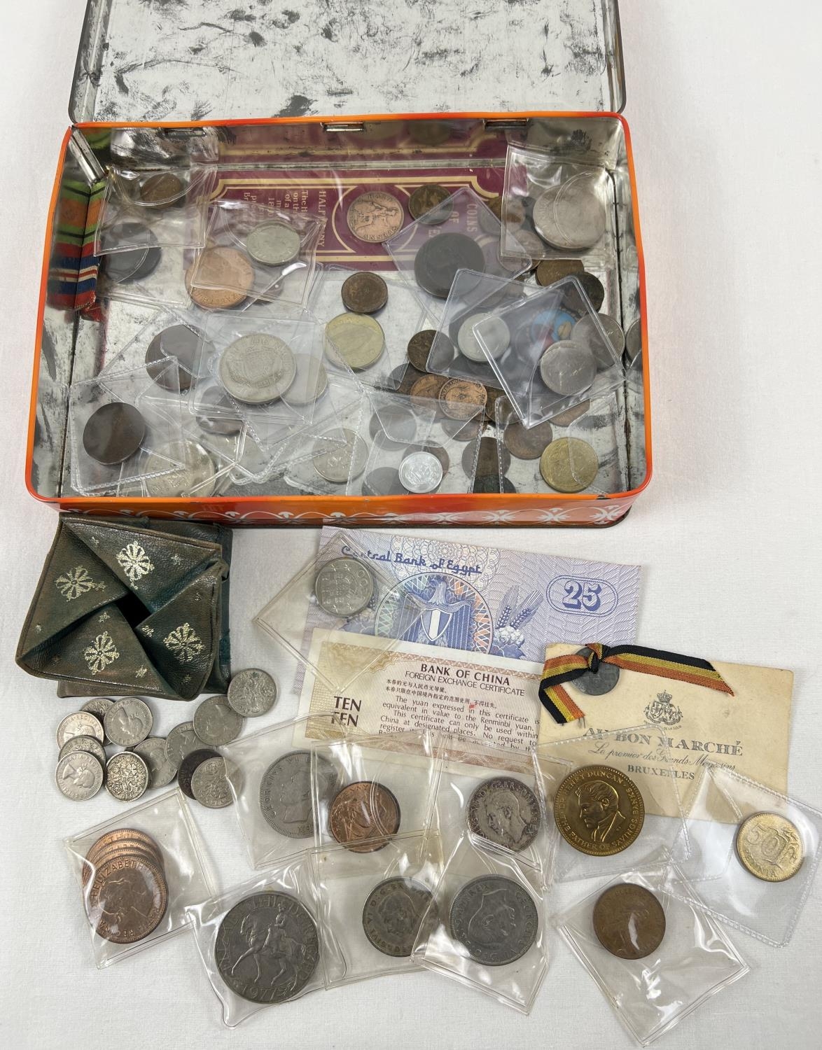 A tin containing a collection of British and foreign vintage coins and bank notes. To include