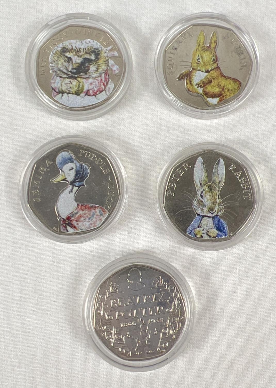 A set of 5 2016 Beatrix Potter commemorative 50p coins with coloured decals. In clear plastic cases.