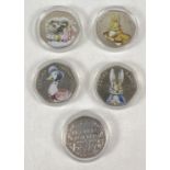 A set of 5 2016 Beatrix Potter commemorative 50p coins with coloured decals. In clear plastic cases.