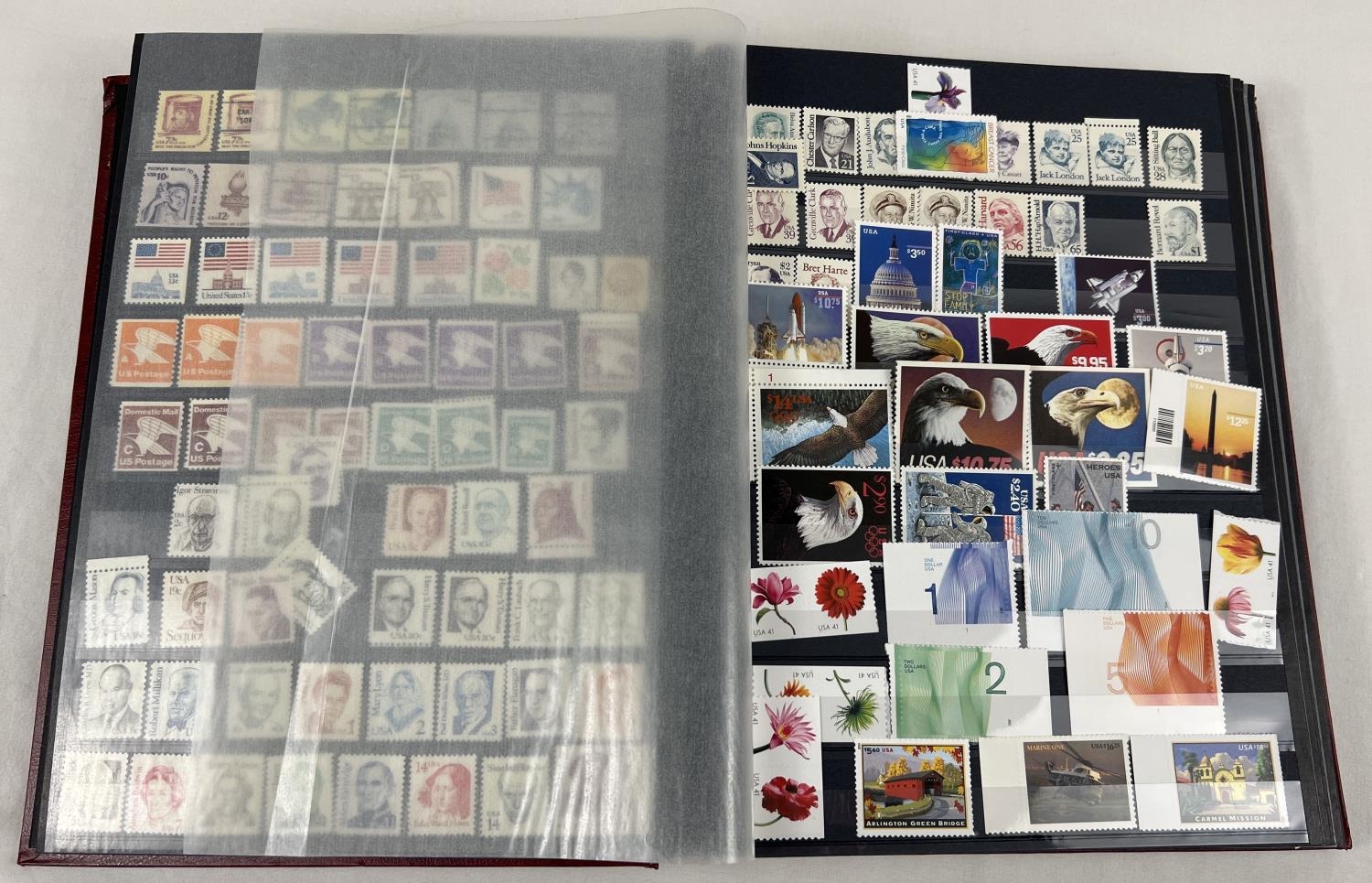 A red stamp album containing a collection of world stamps mostly in mint condition. To include