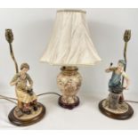 3 table lamps. A pair of ornamental figural lamps featuring a blacksmith & a cobbler, on wooden