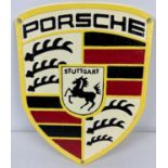A shield shaped cast metal Porsche Wall plaque with painted detail and holes for fixing. Approx.