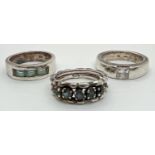 3 silver stone set band style dress rings to include a channel set, baguette cut blue topaz ring.