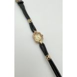 A vintage 9ct gold ladies wristwatch with black leather strap and gold decorative clips by Bernex.