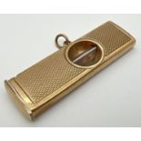A vintage 9ct gold cigar cutter with engine turned decoration to both sides and central hanging
