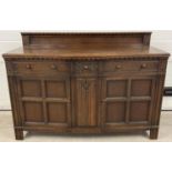 A vintage dark wood Old Charm style sideboard with carved detail and panelled doors. 2 cupboards