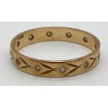A vintage 9ct gold and clear stone set full eternity ring with floral engraved detail. Gold mark