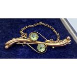 An Edwardian 9ct gold pin back brooch, set with 2 round cut pale green stones. Complete with