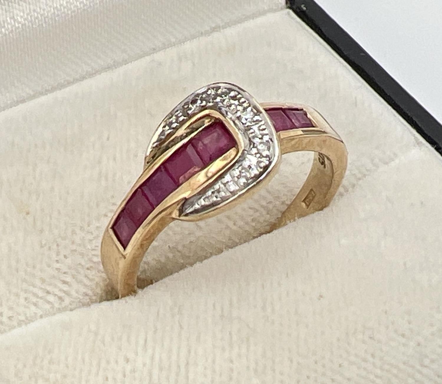 A 9ct gold ruby and diamond set buckle style dress ring. Band channel set with 5 square cut - Image 2 of 4
