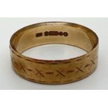 A vintage 9ct gold wedding band with engraved pattern to edges and cross design throughout. Full