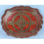 A vintage red and gilt painted wooden ethnic tray, with scalloped design edge. Has had screws put