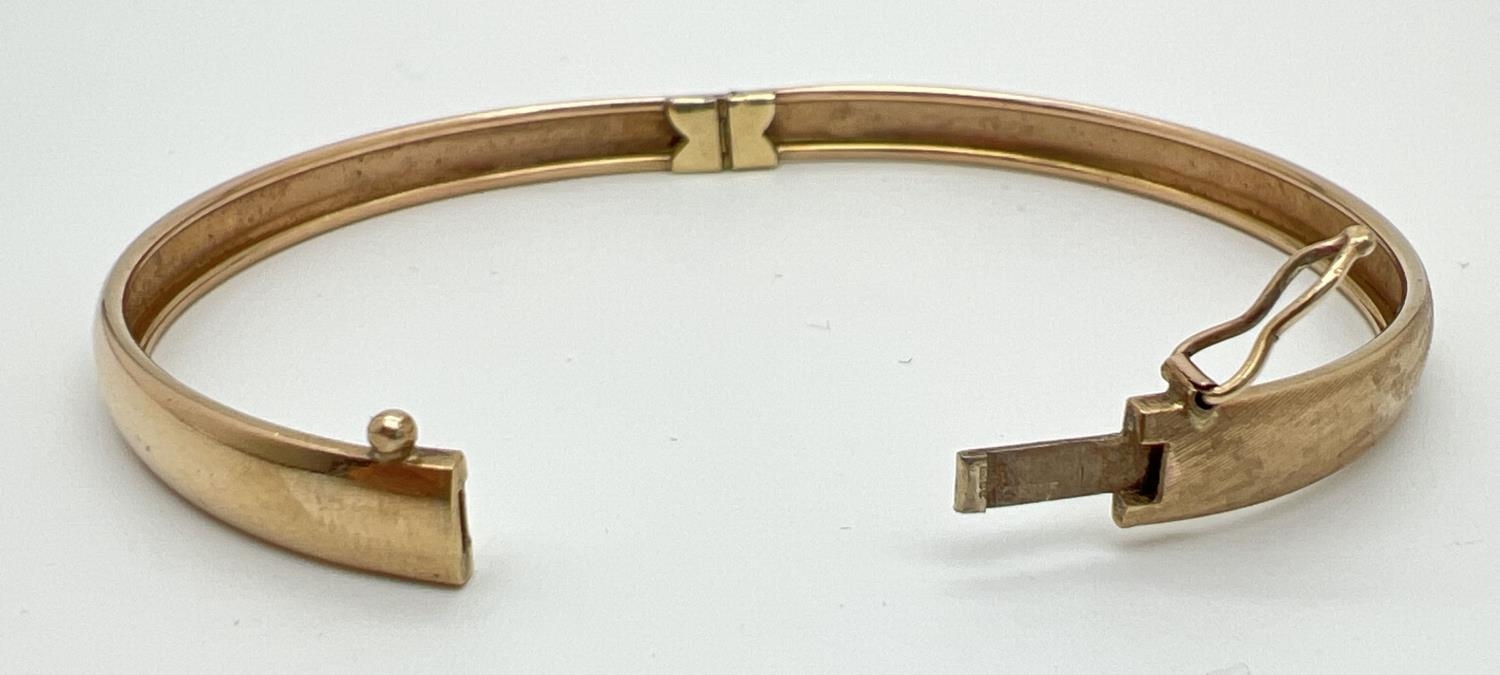 A vintage 9ct gold bangle with half floral engraving and safety clip (in need of attention) to - Image 3 of 3