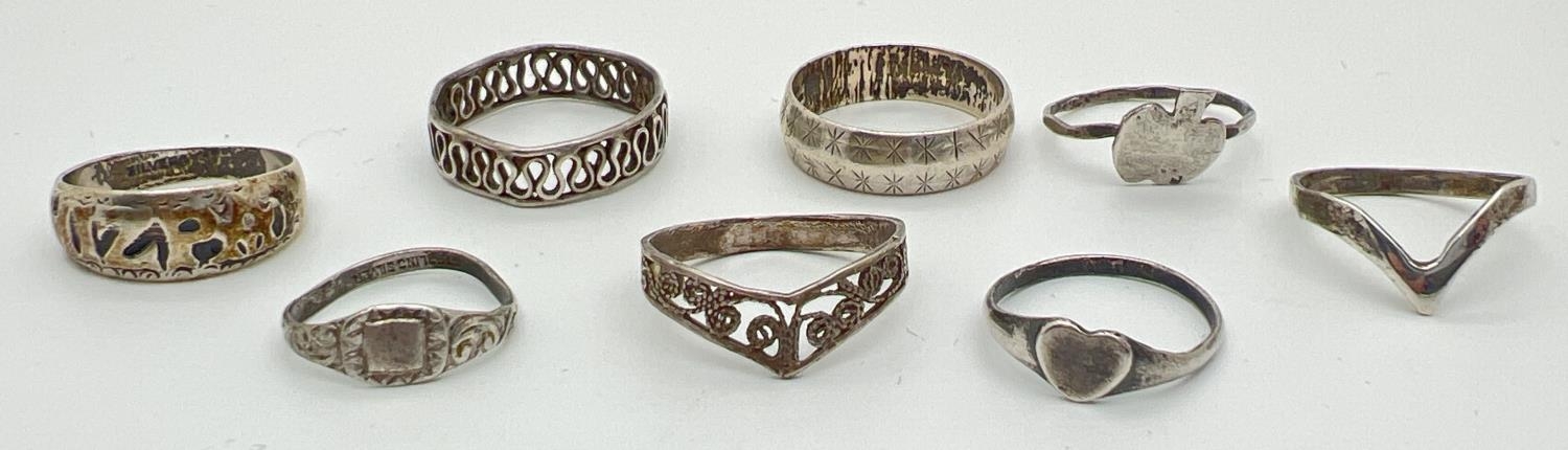 8 silver and white metal rings, mostly band style. To include Mizpah, wishbone and heart shaped