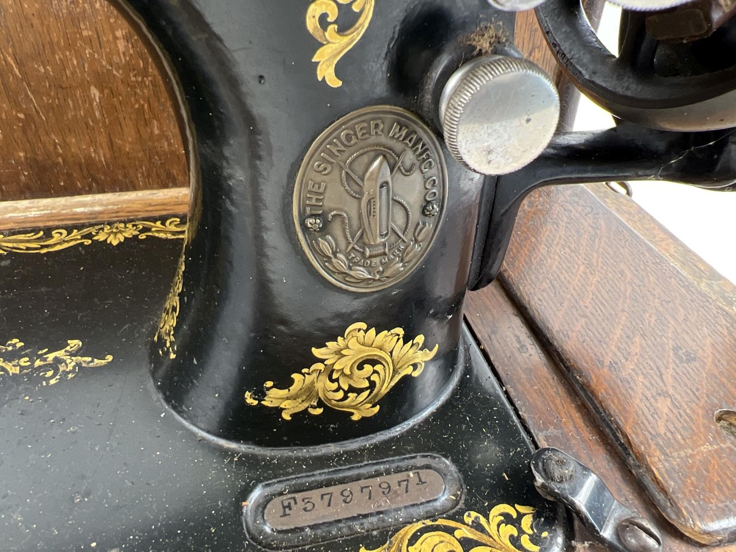 An antique wooden cased Singer sewing machine, black with gold floral decoration and shuttle bobbin. - Image 5 of 6