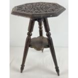A small carved wooden 3 legged occasional table with small under shelf. Floral carving throughout